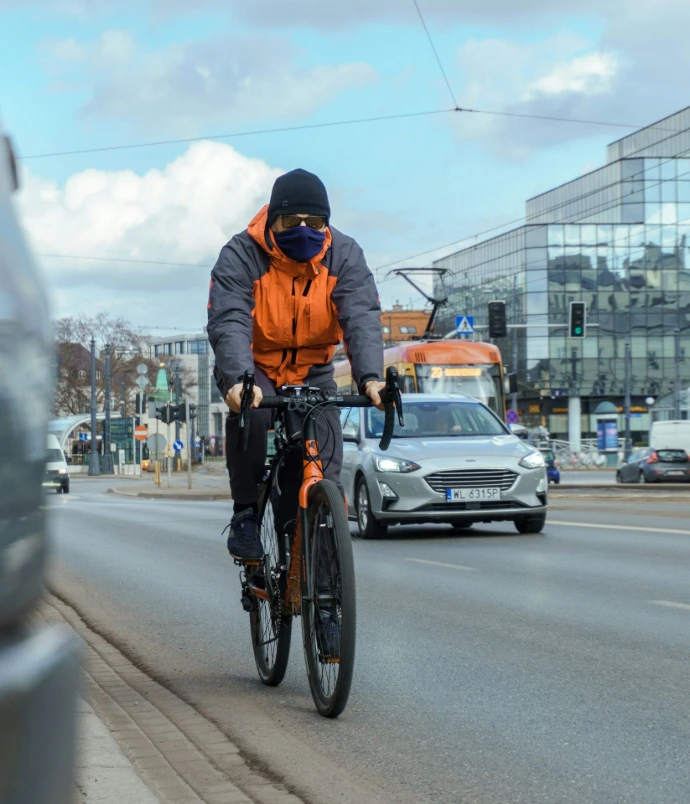 Cyclist pasing by a parked car